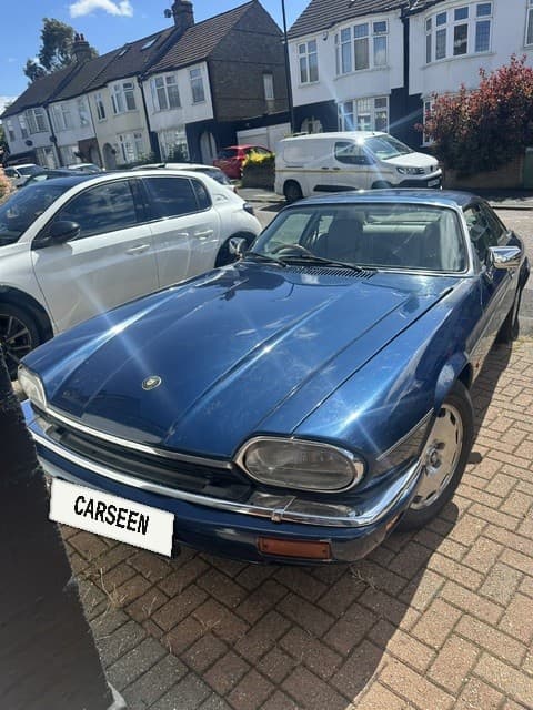 Dark blue 1996 Jaguar XJS Celebration coupé with CarSeen plate on a brick driveway