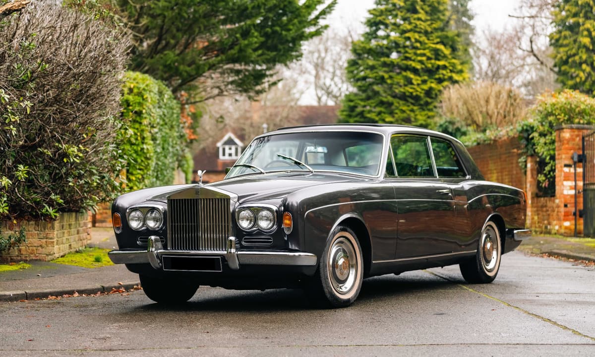 Dark grey Rolls-Royce Silver Shadow parked on a quiet residential street