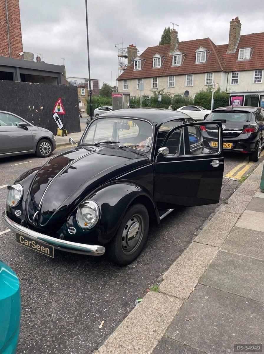Black Volkswagen Beetle with its door open on a London residential street