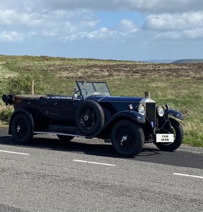 1926 Invicta Tourer in dark blue, side profile with the soft top down, on a moorland road