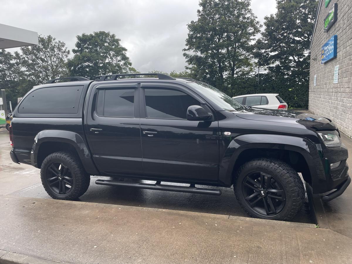 Gloss black 2018 Volkswagen Amarok crew-cab pickup with hardtop canopy in side profile