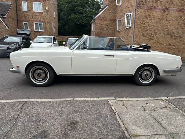 White late-1960s Rolls-Royce drophead convertible in profile with the hood folded