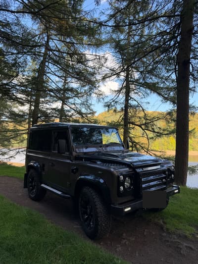 1998 Land Rover Defender 90 in bronze, front three-quarter view by a lake
